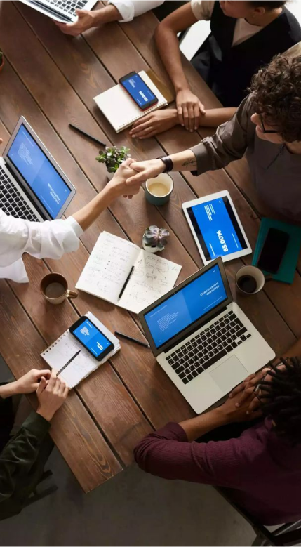 A group of people interacting while working on a laptop